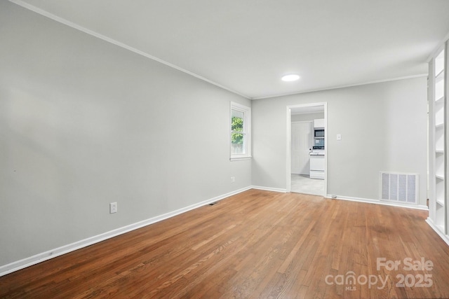 1412 Wembley Dr, Charlotte, NC 28205 - empty room featuring baseboards, wood finished floors, and crown molding