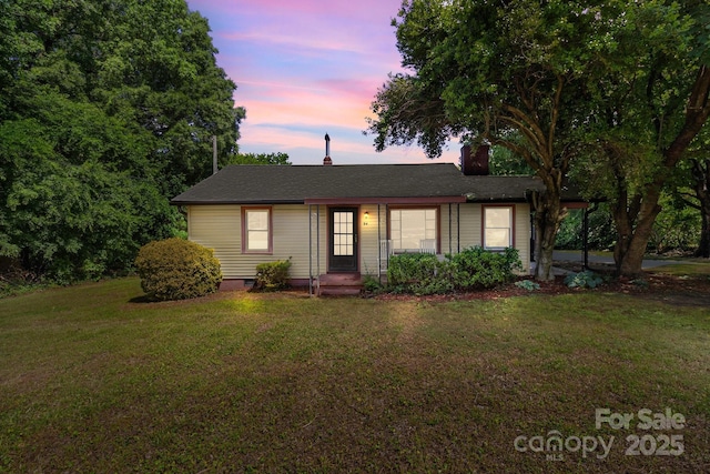 single story home featuring a lawn and a chimney