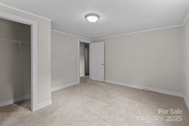 unfurnished bedroom with carpet floors, ornamental molding, a closet, and baseboards