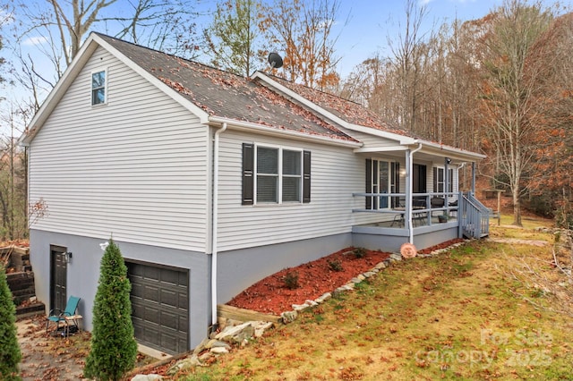 view of property exterior with covered porch and an attached garage