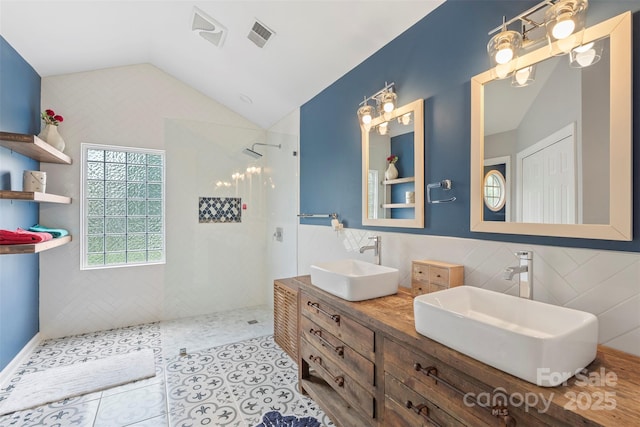 8605 Tamarron Dr, Charlotte, NC 28277 - full bath featuring tile walls, vaulted ceiling, a walk in shower, double vanity, and tile patterned flooring