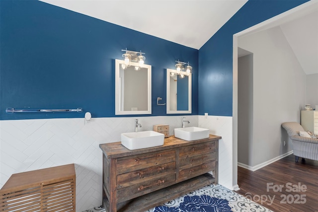 8605 Tamarron Dr, Charlotte, NC 28277 - bathroom with lofted ceiling, wood finished floors, double vanity, and tile walls
