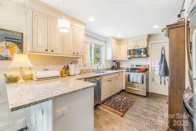6 Craggy Cir, Asheville, NC 28803 - kitchen with appliances with stainless steel finishes, a peninsula, cream cabinetry, light stone counters, and recessed lighting
