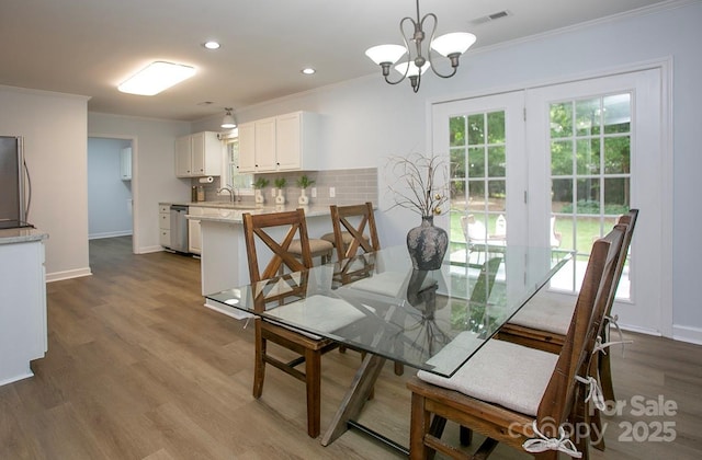 1610 Ford St, Charlotte, NC 28216 - dining area featuring ornamental molding, wood finished floors, baseboards, a chandelier, and recessed lighting