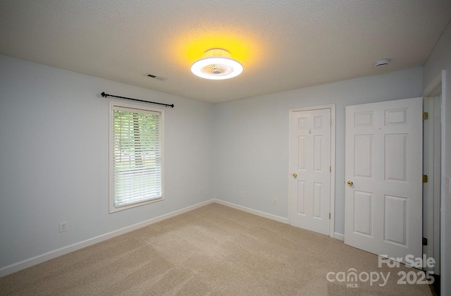 1610 Ford St, Charlotte, NC 28216 - spare room featuring light carpet, a textured ceiling, baseboards, and a smoke detector