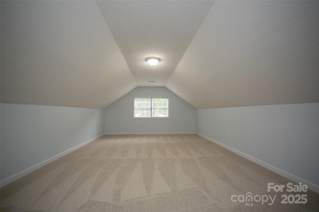 1610 Ford St, Charlotte, NC 28216 - additional living space featuring a textured ceiling, vaulted ceiling, baseboards, and light colored carpet