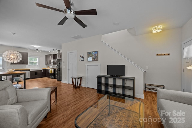 living area featuring ceiling fan, wood finished floors, and baseboards