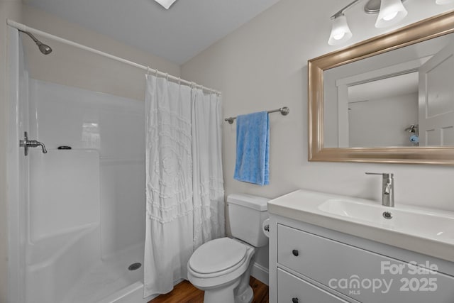 bathroom featuring toilet, vanity, a shower with curtain, and wood finished floors