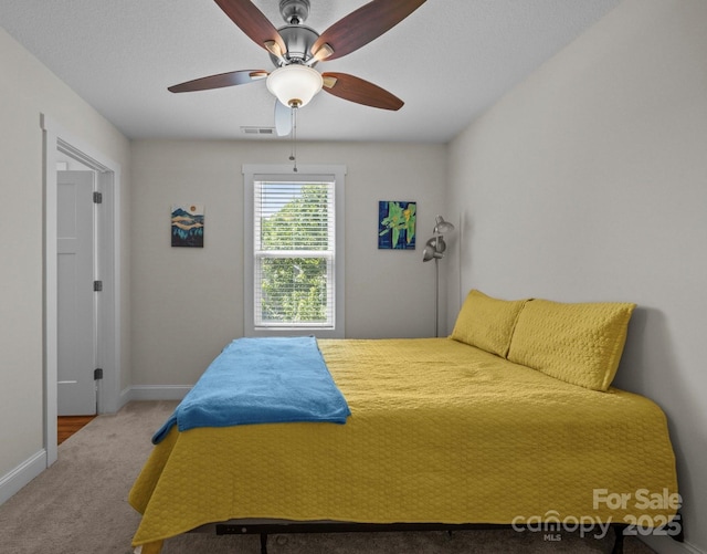 carpeted bedroom featuring baseboards and a ceiling fan