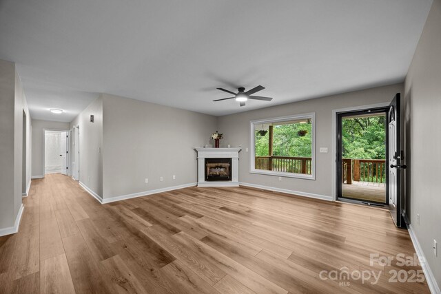 16 Lake Forest Ln, Hendersonville, NC 28739 - unfurnished living room with a ceiling fan, light wood-style flooring, baseboards, and a fireplace