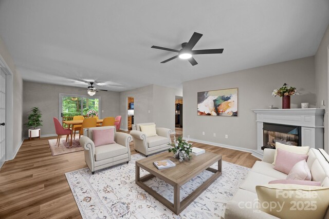 16 Lake Forest Ln, Hendersonville, NC 28739 - living area featuring ceiling fan, light wood-type flooring, a fireplace with raised hearth, and baseboards