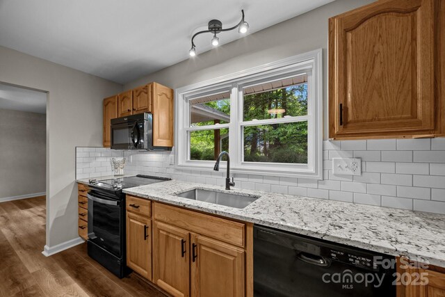 16 Lake Forest Ln, Hendersonville, NC 28739 - kitchen with black appliances, a sink, dark wood finished floors, light stone countertops, and decorative backsplash