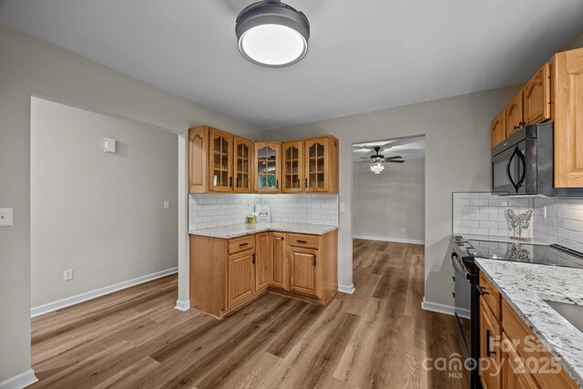 16 Lake Forest Ln, Hendersonville, NC 28739 - kitchen with black appliances, wood finished floors, tasteful backsplash, and baseboards