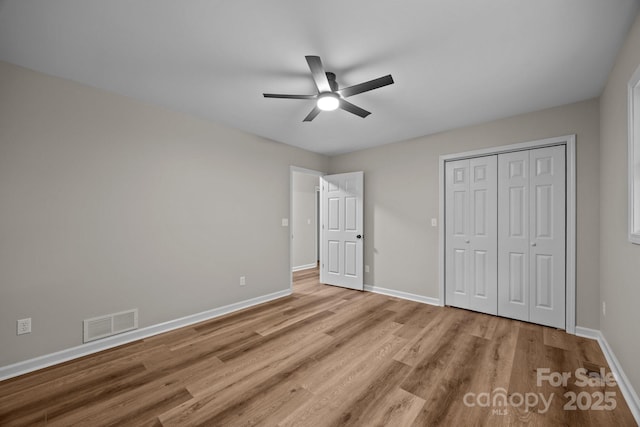 16 Lake Forest Ln, Hendersonville, NC 28739 - unfurnished bedroom featuring light wood-style floors, baseboards, a closet, and a ceiling fan
