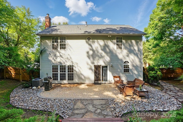 8744 Barrister Way, Charlotte, NC 28216 - rear view of property featuring a chimney, a fenced backyard, central AC unit, and a patio area