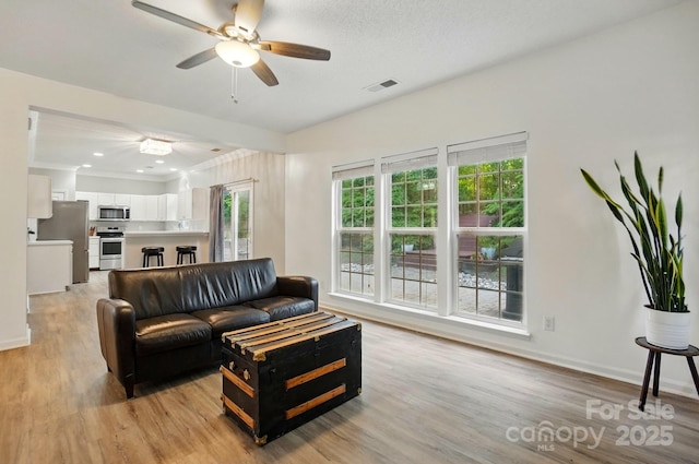 8744 Barrister Way, Charlotte, NC 28216 - living room featuring a ceiling fan, light wood finished floors, baseboards, and crown molding