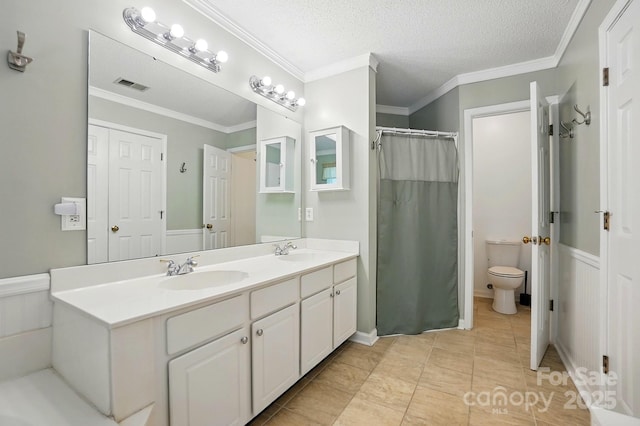 8744 Barrister Way, Charlotte, NC 28216 - bathroom with double vanity, toilet, wainscoting, ornamental molding, and a textured ceiling