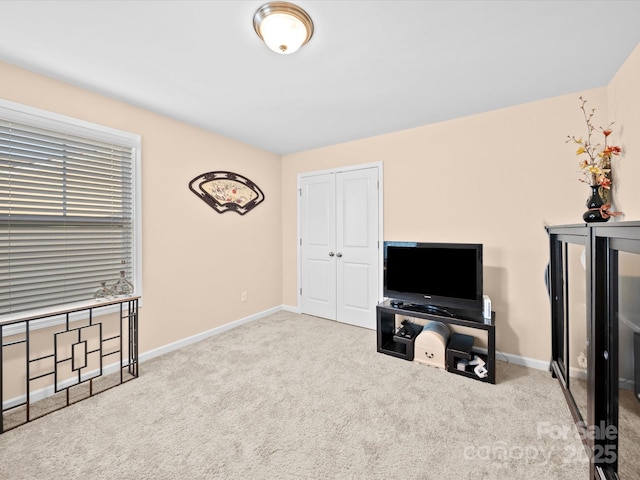 carpeted bedroom featuring baseboards and a closet
