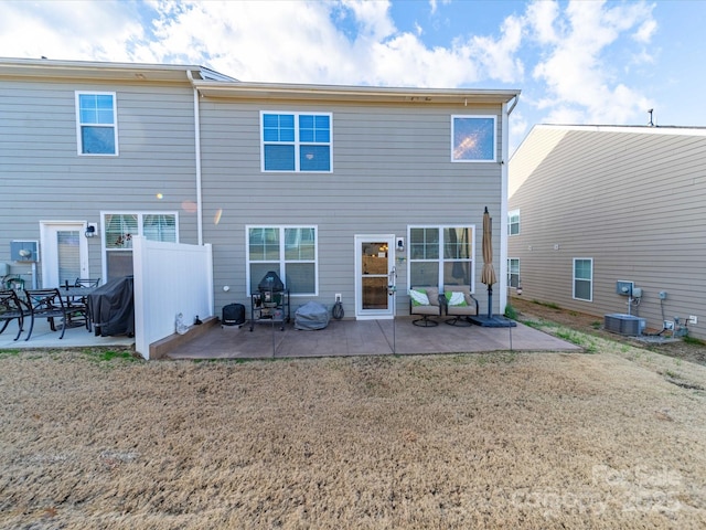 rear view of property featuring a patio, a lawn, and central AC