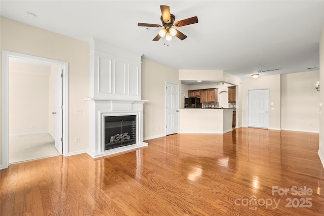 14853 Santa Lucia Dr, Charlotte, NC 28277 - unfurnished living room with a ceiling fan, a fireplace, light wood-style floors, and baseboards