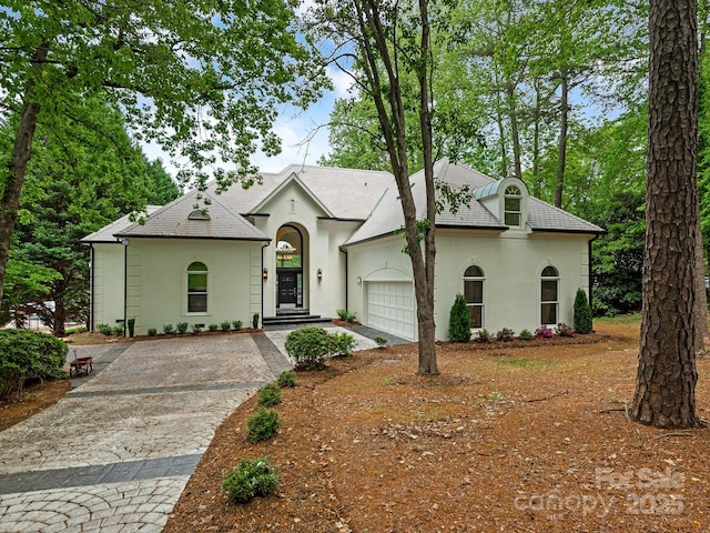 21404 Blakely Shores Dr, Cornelius, NC 28031 - french country home featuring stucco siding, a garage, and decorative driveway