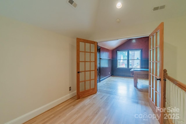 416 E Park Ave, Charlotte, NC 28203 - spare room featuring vaulted ceiling, wood finished floors, and french doors