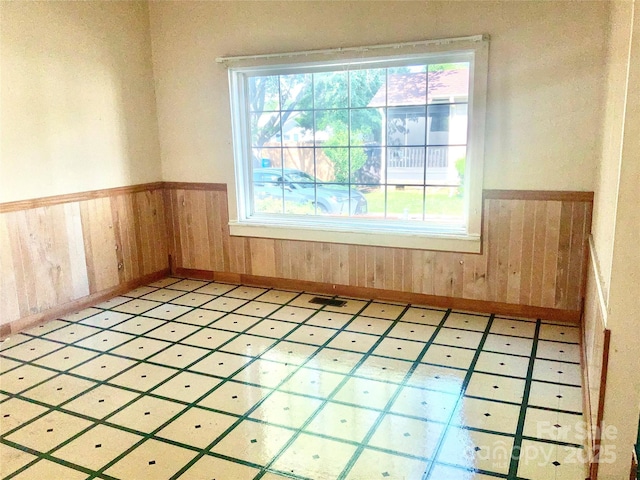 447 17th St, Cramerton, NC 28032 - empty room featuring a wainscoted wall, plenty of natural light, wood walls, and baseboards