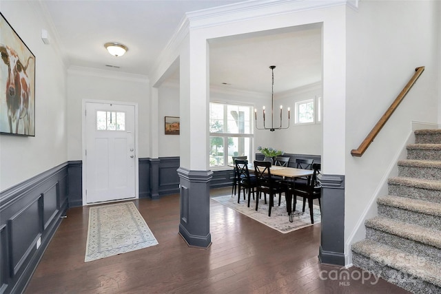 8916 Inverness Bay Rd, Charlotte, NC 28278 - foyer entrance featuring a chandelier, stairway, dark wood finished floors, a wainscoted wall, and ornamental molding