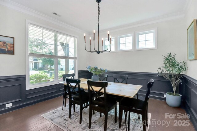 8916 Inverness Bay Rd, Charlotte, NC 28278 - dining room featuring wainscoting, a chandelier, healthy amount of natural light, ornamental molding, and wood finished floors