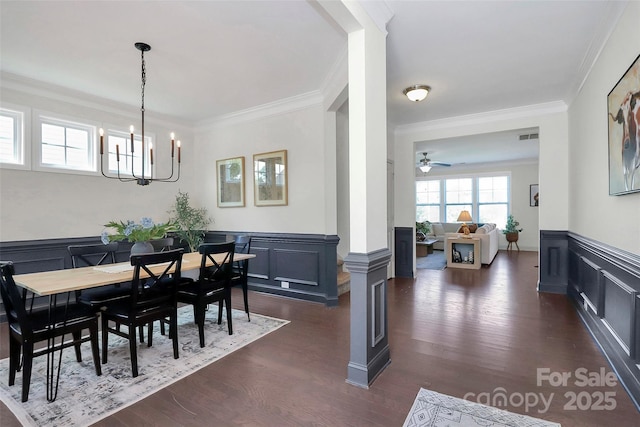 8916 Inverness Bay Rd, Charlotte, NC 28278 - dining area featuring a chandelier, wainscoting, a decorative wall, crown molding, and dark wood-type flooring