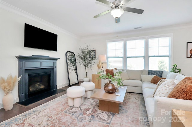 8916 Inverness Bay Rd, Charlotte, NC 28278 - living room featuring a glass covered fireplace, ornamental molding, wood finished floors, ceiling fan, and baseboards