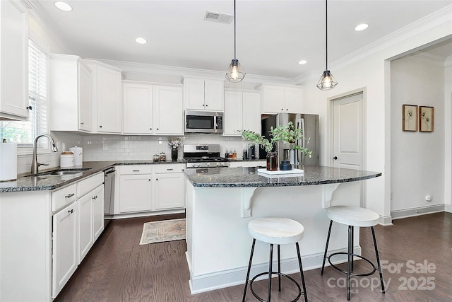 8916 Inverness Bay Rd, Charlotte, NC 28278 - kitchen with a sink, appliances with stainless steel finishes, dark wood finished floors, a center island, and crown molding