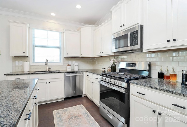 8916 Inverness Bay Rd, Charlotte, NC 28278 - kitchen with stainless steel appliances, a sink, dark wood-type flooring, dark stone countertops, and crown molding