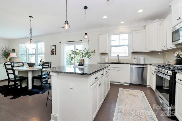 8916 Inverness Bay Rd, Charlotte, NC 28278 - kitchen featuring stainless steel appliances, a sink, a kitchen island, crown molding, and decorative backsplash