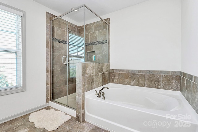 8916 Inverness Bay Rd, Charlotte, NC 28278 - bathroom featuring healthy amount of natural light, a garden tub, a stall shower, and baseboards