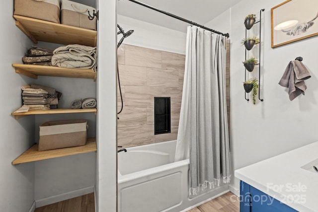 bathroom with wood finished floors, shower / tub combo with curtain, and baseboards