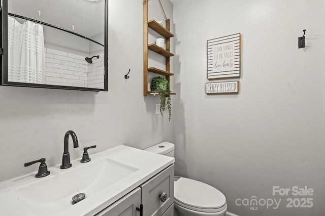 bathroom with toilet, vanity, and curtained shower