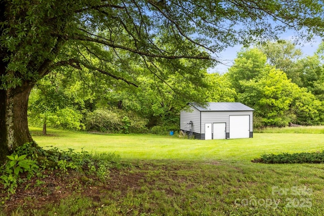 view of grassy yard featuring a garage and an outbuilding