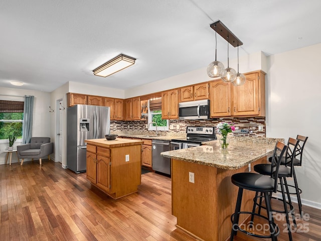 26 Morrow Dr, Fairview, NC 28730 - kitchen with appliances with stainless steel finishes, backsplash, a peninsula, and light wood-type flooring
