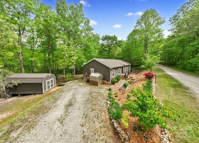 281 Crooked Creek Est, Old Fort, NC 28762 - view of front of home featuring an outdoor structure, a wooden deck, dirt driveway, and a view of trees