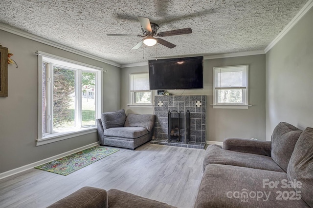 3803 Cook Rd, Valdese, NC 28690 - living room with healthy amount of natural light, a tiled fireplace, ceiling fan, a textured ceiling, and crown molding