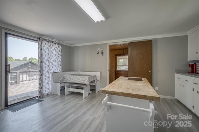3803 Cook Rd, Valdese, NC 28690 - kitchen with crown molding, light wood-style flooring, wood counters, white cabinetry, and a kitchen island