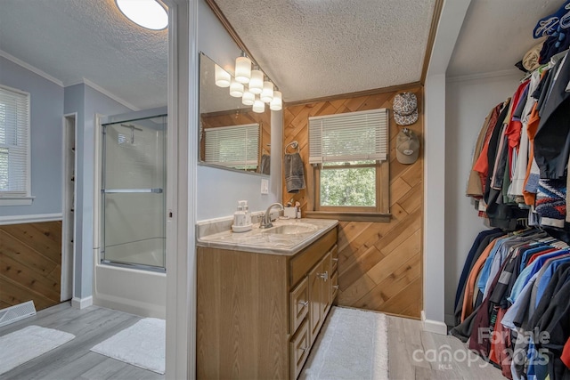 3803 Cook Rd, Valdese, NC 28690 - bathroom featuring wood walls, vanity, wood finished floors, a textured ceiling, and shower / bath combination with glass door