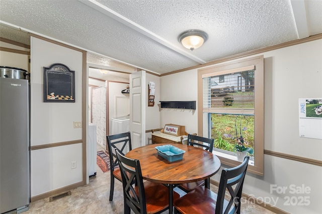 2496 Messer St, Valdese, NC 28690 - dining area with a textured ceiling, washer / clothes dryer, crown molding, baseboards, and vaulted ceiling