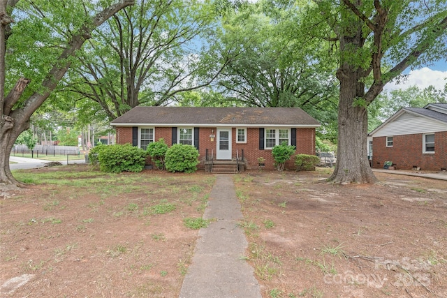 ranch-style house featuring brick siding and fence