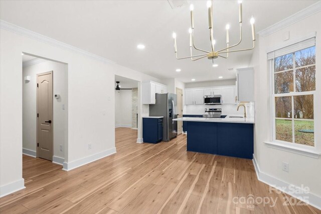 130 Valley Glen Dr, Troutman, NC 28166 - kitchen featuring stainless steel appliances, a sink, ornamental molding, light countertops, and a chandelier
