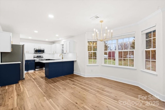 130 Valley Glen Dr, Troutman, NC 28166 - kitchen featuring appliances with stainless steel finishes, a chandelier, a peninsula, light wood-style floors, and baseboards