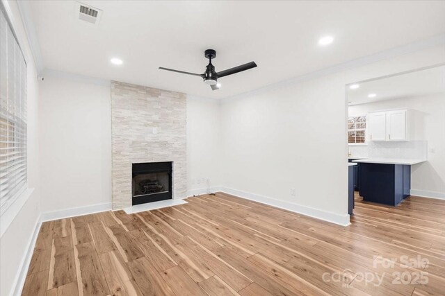 130 Valley Glen Dr, Troutman, NC 28166 - unfurnished living room with a ceiling fan, light wood-style flooring, crown molding, a fireplace, and baseboards