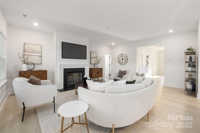 219 Tillery Ln Unit 755, Mount Gilead, NC 27306 - living room featuring light wood-style flooring, recessed lighting, a fireplace with flush hearth, and baseboards