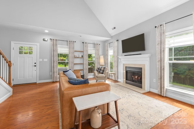 516 King St, Waxhaw, NC 28173 - living room featuring a fireplace with flush hearth, wood finished floors, baseboards, stairs, and recessed lighting